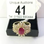 An 14ct gold diamond sunburst cluster ring set with central ruby, size S