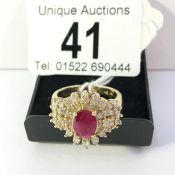 An 14ct gold diamond sunburst cluster ring set with central ruby, size S