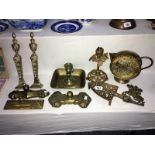 A mixed lot of brassware including candlesticks, door stops, jug etc