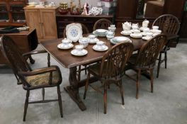 An oak refectory table with a set of 6 wheel back chairs