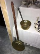 A brass warming pan and a brass saucepan