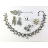 A diamonte necklace, a pair of diamonte earrings, 2 diamonte brooches and a pearl brooch