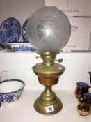 A brass oil lamp with etched shade (missing chimney)