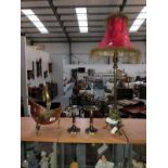 A brass based table lamp, a pair of candle stands and a small copper coal helmet