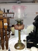 A Victorian brass column oil lamp with pink glass font