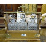 Set of 3 cut glass square shaped decanters, in mahogany tantalus case with brass mounts.