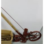 Metal Garden Seeder, with single wheel, painted red with wooden handle