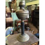 Victorian oil lamp with ceramic stem brass bowl.