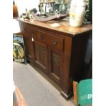 Victorian carved oak side board the three long drawers above two doors.