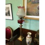 Oil lamp with brass base and column ruby glass bowl and etched tulip shade.