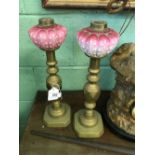 Pair of Victorian brass lamps with pink glass shades.
