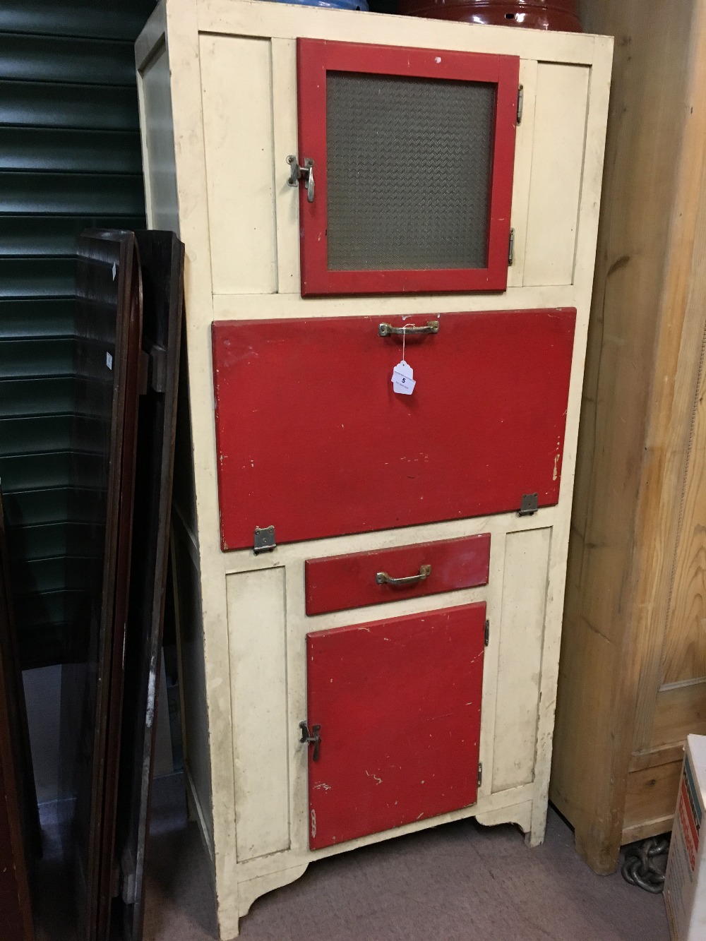 1930's kitchen cabinet the glazed door above a fallfront single drawer and door.