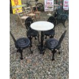 Garden set of four cast iron chairs and a cast iron marble topped table.