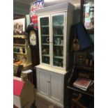 Painted pine bookcase with two glazed doors over two panelled doors.