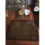 Brass memorial plaque and clock in the form of a horseshoe.