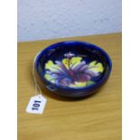 MID 20TH CENTURY MOORCROFT PEDESTAL DISH DECORATED IN CORAL HIBISCUS PATTERN ON A BLUE GROUND A/F