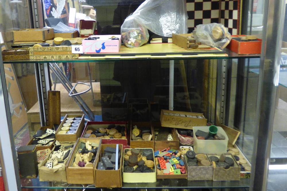 TWO SHELVES OF ASSORTED DOMINOES, PLAYING CARDS, CHESS PIECES, DRAUGHTS PIECES, CRIBBAGE BOARD,