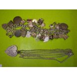 SILVER CHARM BRACELET WITH PADLOCK CLASP AND NUMEROUS NOVELTY CHARMS AND COINS AND A HEART SHAPED