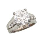 SILVER RING set with a European cut diamond (3.05ct.) flanked by 6 small brilliant cut diamonds,