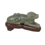 A JADE DOG WITH A STAND, 19TH CENTURY 19世紀 玉臥犬 Of reseda green tones with areas of white and spinach