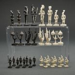AFRICAN CARVED IVORY FIGUAL TRIBAL CHESS SET, MID 20TH CENTURYone side stained black the other