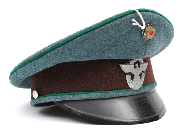 A Third Reich Police officer’s peaked cap, of green felt with apple green piping, brown band,