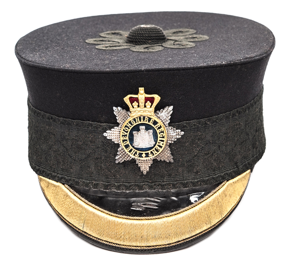 A good Victorian officer’s peaked forage cap of The Devonshire Regiment, of blue cloth with black