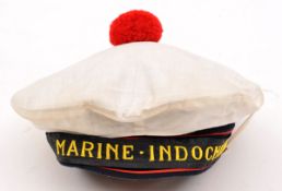 †A “Marine Indochine” round cap, embroidered title headband with scarlet edge piping, scarlet wool