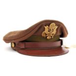 †A WWII US Army officer’s khaki peaked cap, brown leather peak and chinstrap, gilt buttons and