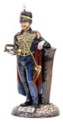 A Michael Sutty painted porcelain figure “Trumpeter RHA”, in full dress with busby and cape, holding