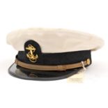 †A US Naval Petty Officer’s peaked cap, white top, black headband and PL peak, gilt chinstrap,