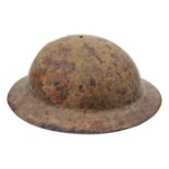 A WWI “raw edged” steel helmet, with loops for chinstrap and part of the strap with buckles, (