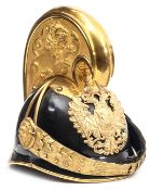 †An Austrian dragoon officer’s helmet, Model 1905, black patent leather skull, gilt binding to front