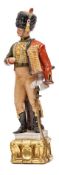 A painted porcelain figure of a Napoleonic Hussar officer, in full dress with busby and pelisse,