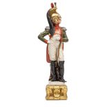A painted porcelain figure of a Napoleonic Dragoon officer, in full dress with plumed helmet and