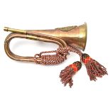 A copper and brass bugle, applied A & SH badge, coloured cords and tassels, and a small brass