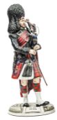 A large Michael Sutty painted porcelain figure “Pipe Major Scots Guards”, in full dress with