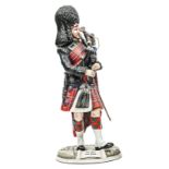 A large Michael Sutty painted porcelain figure “Pipe Major Scots Guards”, in full dress with