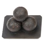 An interesting desk ornament comprising 3 canister (?) shot balls affixed to a brass base plate