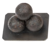 An interesting desk ornament comprising 3 canister (?) shot balls affixed to a brass base plate
