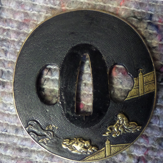 A Shakudo Nanako tsuba, with gilt figures on bridge, in modern box.