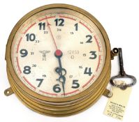 A Third Reich Kriegsmarine brass bulkhead clock, the silvered dial with black hour numerals, red