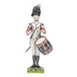 A continental painted porcelain figure “Drummer 1792 First Guards”, in full dress with side drum