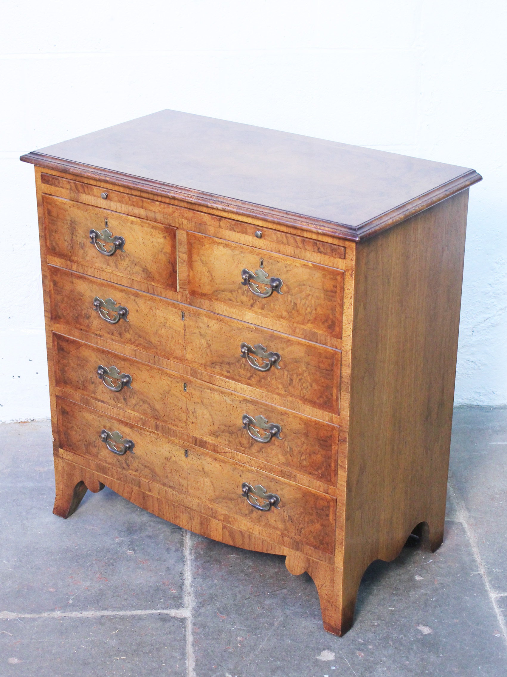 A good quality reproduction Georgian style chest of drawers with brushing slide and splayed legs.