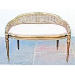 A French gilt wood and bergere dressing table stool. L90cm