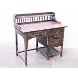 An Edwardian Arts & Crafts style oak writing desk, the spindle back having heart shape cut outs to