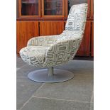 An Italian "Brend" armchair by Natuzzi with square form patterned fabric on satin metal swivel base.