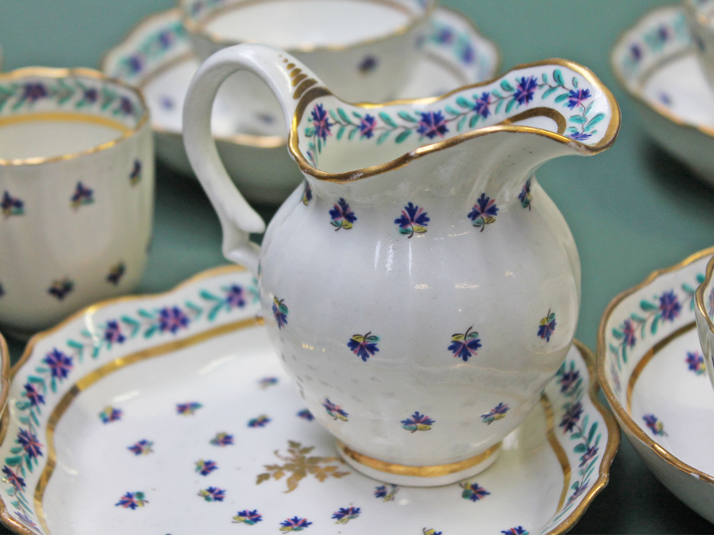 An English porcelain part tea set circa 1800 comprising five tea bowls and saucers, a cream jug, a