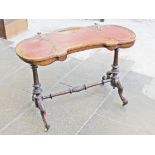 A Victorian burr walnut leather top writing table with turned supports, stretcher and scroll legs.