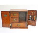 An early 20th Century oak smokers cabinet with three vintage pipes. H33cm.